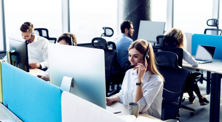 A female IT support professional is talking to a customer in an office setting