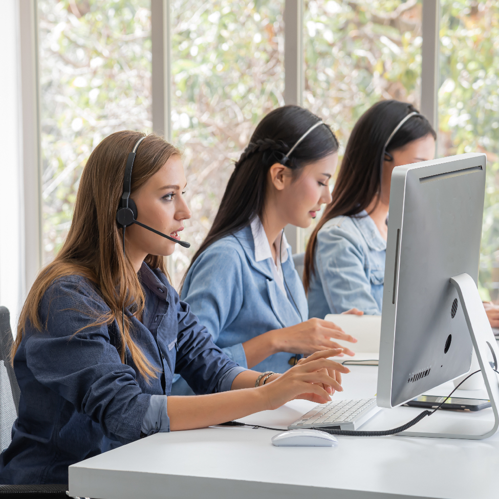 A female IT support professional is talking to a customer in an office setting