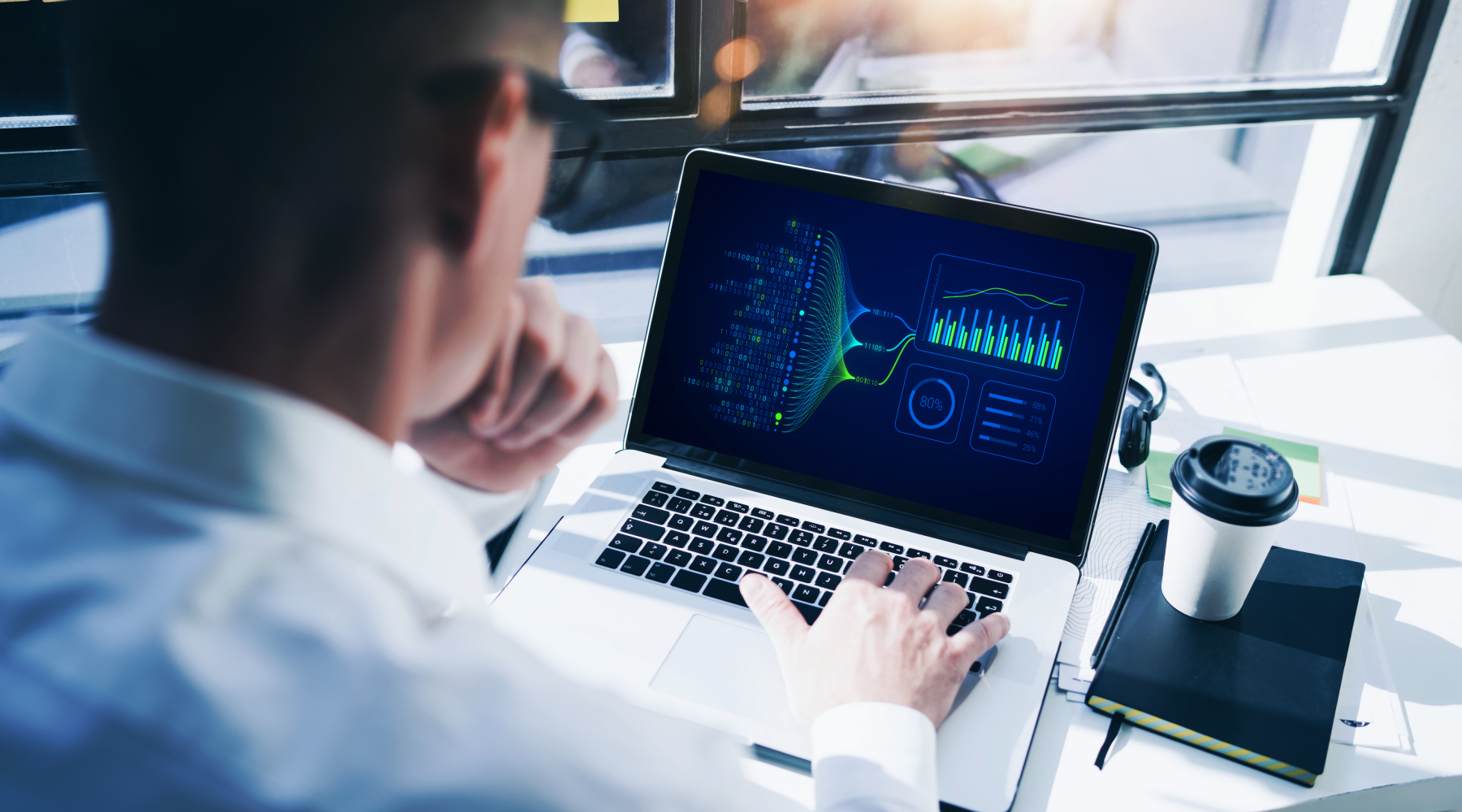 A male engineer is working on a laptop to organize data for an advanced analytics project