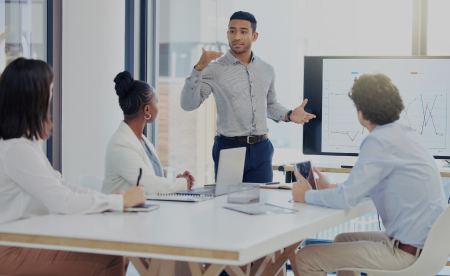 A male IT professional is presenting his ideas to his colleagues in a conference room