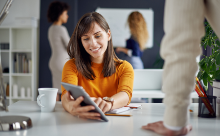 A female engineer presenting a plan to her colleague in an office setting