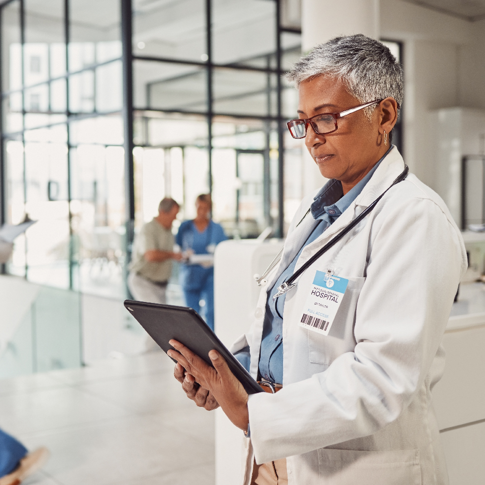 A female healthcare professional is analyzing patient data on a tablet screen