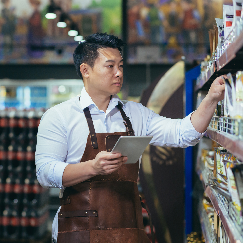 A retail store manager is checking the items in the store using his tablet