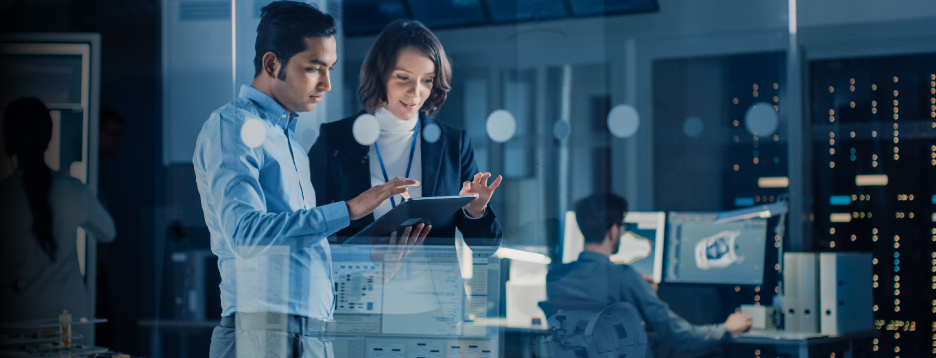 A male and a female IT professional discussing a technology project on a tablet