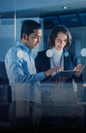 A male and a female IT professional discussing a technology project on a tablet